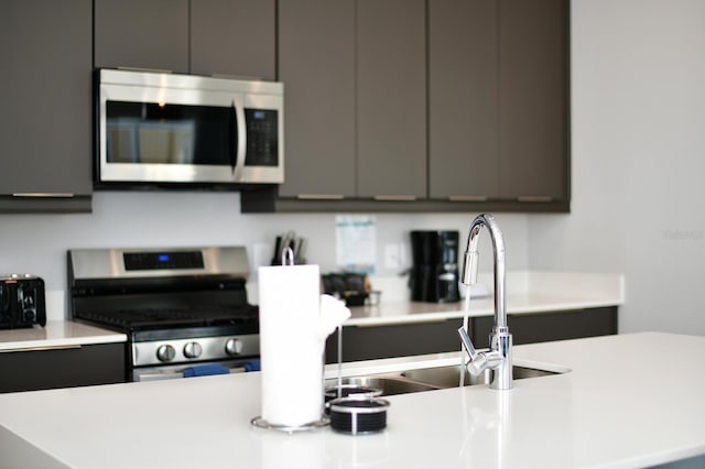 kitchen with modern cabinets, appliances with stainless steel finishes, gray cabinets, and light countertops