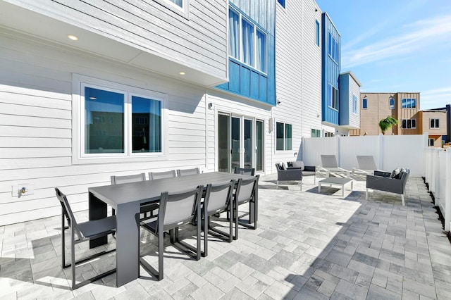 view of patio featuring outdoor lounge area, outdoor dining area, and fence