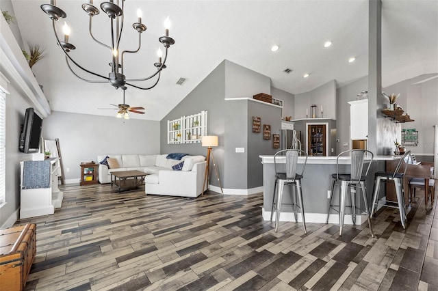 kitchen featuring wood finished floors, visible vents, a peninsula, freestanding refrigerator, and ceiling fan with notable chandelier