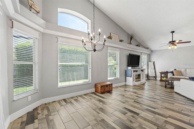 living area with ceiling fan with notable chandelier, light wood-type flooring, and baseboards