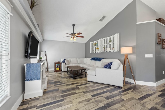 living room with wood finished floors, baseboards, visible vents, ceiling fan, and vaulted ceiling