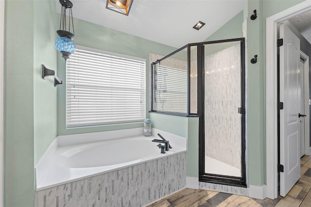 full bathroom with a bath, a shower stall, and vaulted ceiling