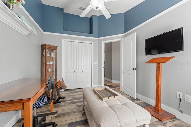 home office featuring visible vents, baseboards, a ceiling fan, and wood finished floors