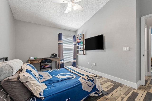 bedroom with a textured ceiling, wood finished floors, baseboards, ceiling fan, and vaulted ceiling