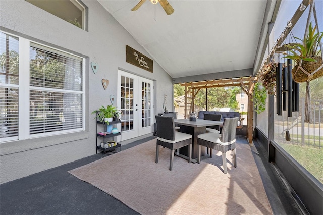 sunroom / solarium featuring vaulted ceiling, a ceiling fan, and french doors