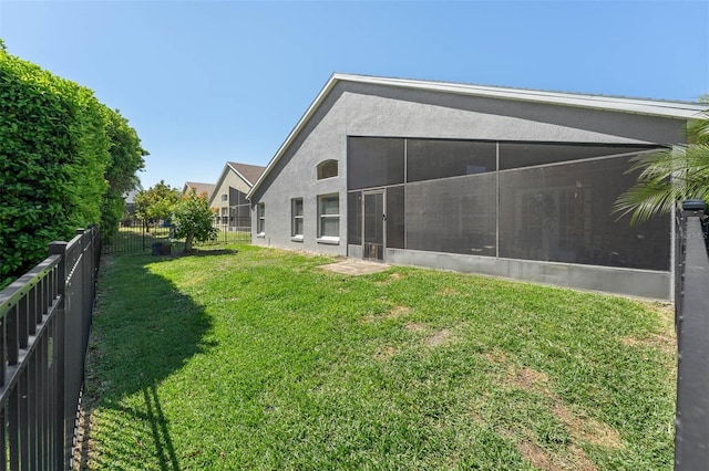 view of yard with a fenced backyard and a sunroom