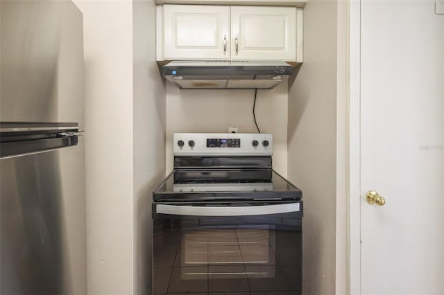 2108 W 15th, Jacksonville, FL 32209 - kitchen with tile patterned floors, white cabinets, under cabinet range hood, and stainless steel appliances