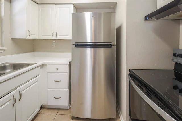2108 W 15th, Jacksonville, FL 32209 - kitchen featuring light tile patterned flooring, light countertops, white cabinets, under cabinet range hood, and appliances with stainless steel finishes