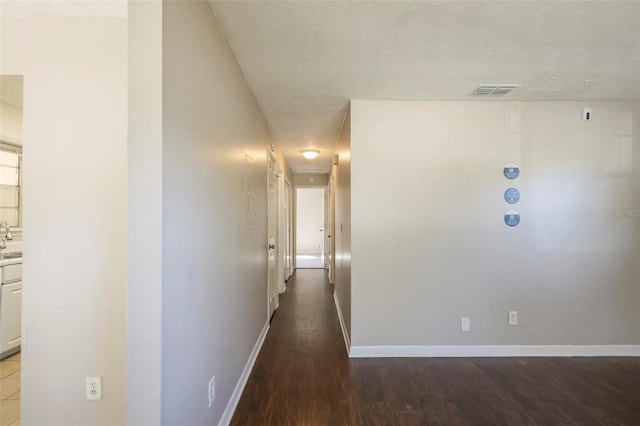 2108 W 15th, Jacksonville, FL 32209 - hallway featuring wood finished floors, visible vents, baseboards, a sink, and a textured ceiling