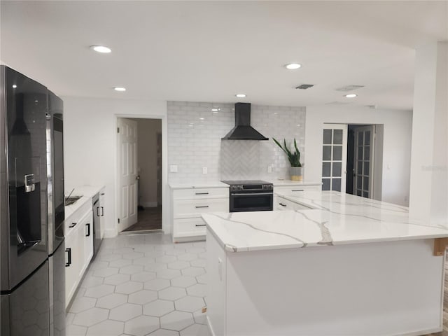 kitchen featuring tasteful backsplash, range with electric cooktop, wall chimney range hood, refrigerator with ice dispenser, and white cabinets