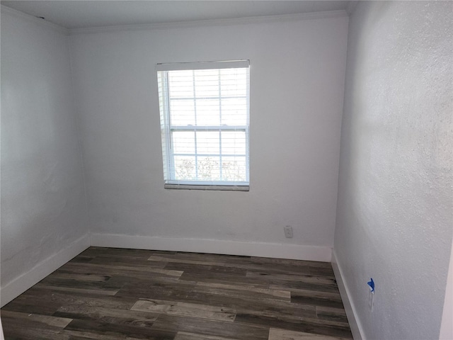 unfurnished room featuring dark wood-type flooring, baseboards, and ornamental molding