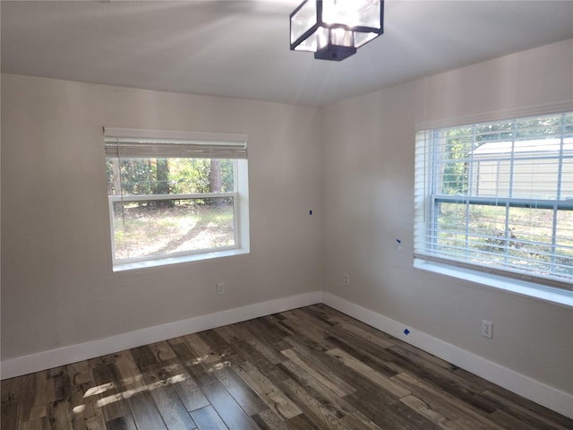 spare room featuring wood finished floors and baseboards