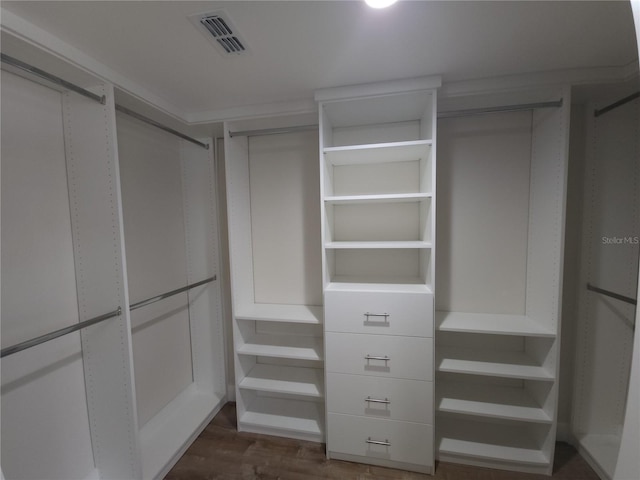 spacious closet with dark wood-type flooring and visible vents