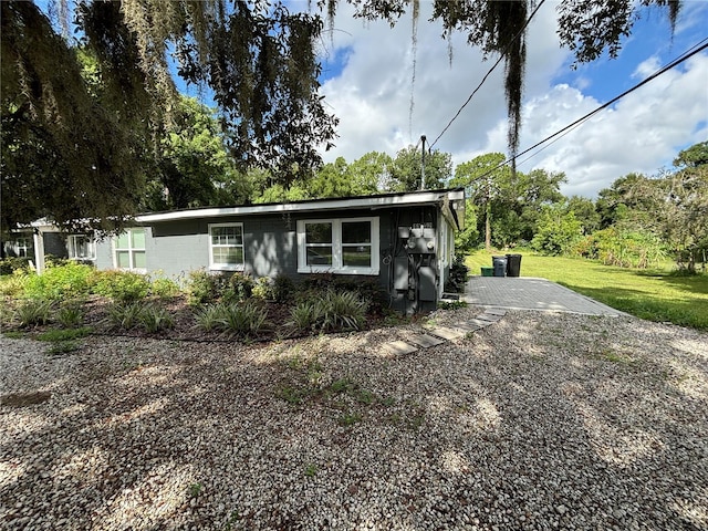 view of front of home with concrete block siding and a front yard