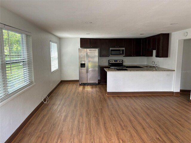 kitchen with baseboards, appliances with stainless steel finishes, and wood finished floors