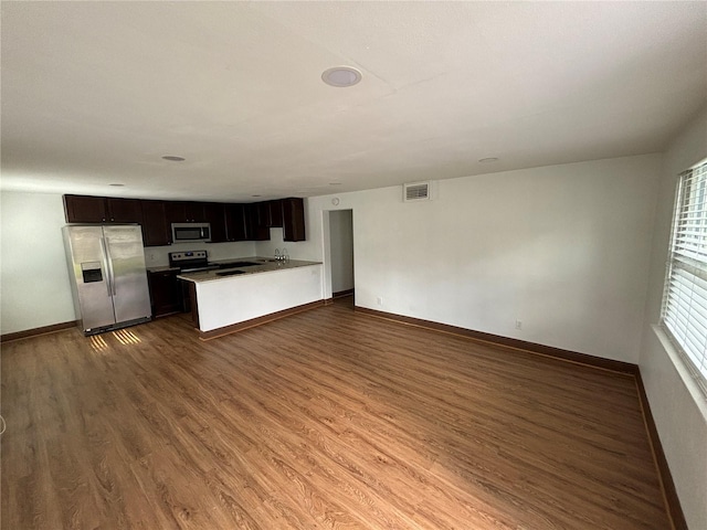 kitchen featuring visible vents, open floor plan, appliances with stainless steel finishes, baseboards, and dark wood-style flooring