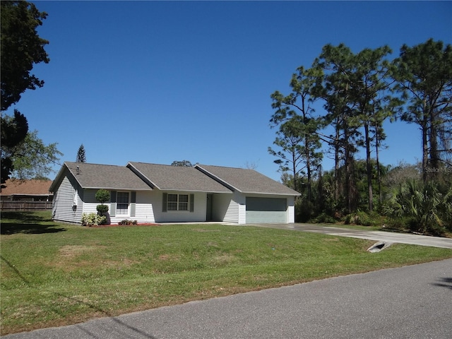 view of front of home with a garage, a front yard, and driveway