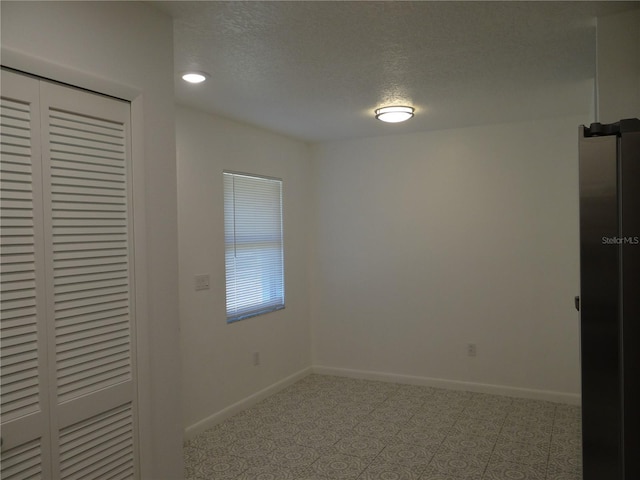 unfurnished bedroom with a closet, baseboards, and a textured ceiling