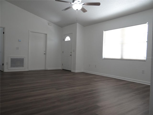 interior space with baseboards, visible vents, lofted ceiling, dark wood-style flooring, and ceiling fan