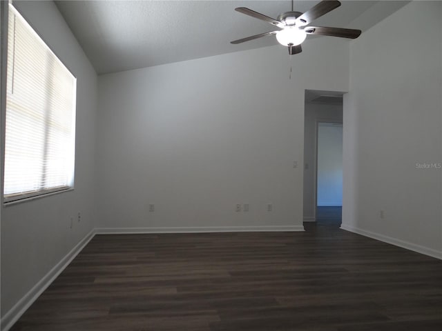 unfurnished room with dark wood-style floors, ceiling fan, baseboards, and vaulted ceiling