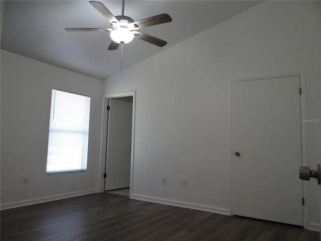 spare room featuring ceiling fan, baseboards, dark wood-style floors, and vaulted ceiling