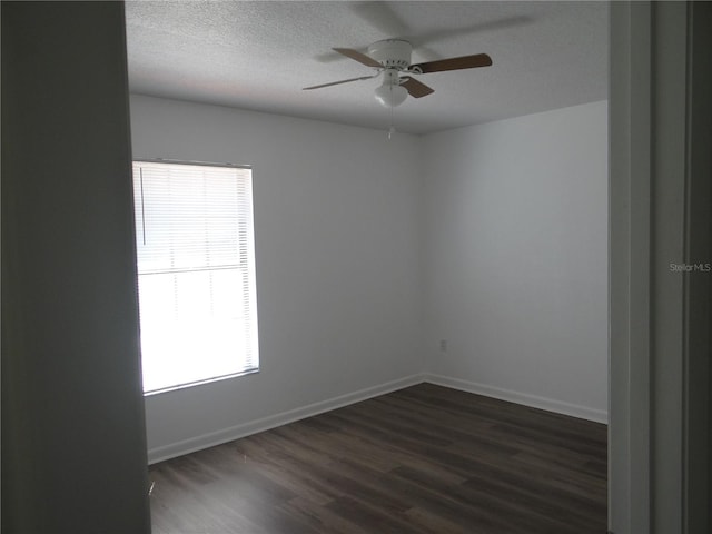 unfurnished room with dark wood finished floors, a ceiling fan, baseboards, and a textured ceiling