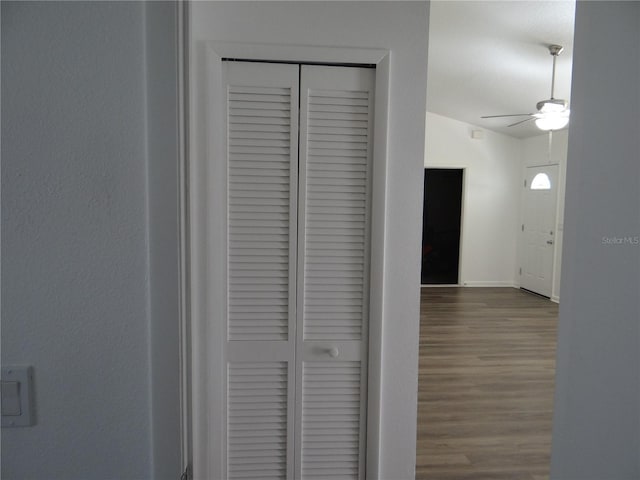 hallway with vaulted ceiling, baseboards, and wood finished floors