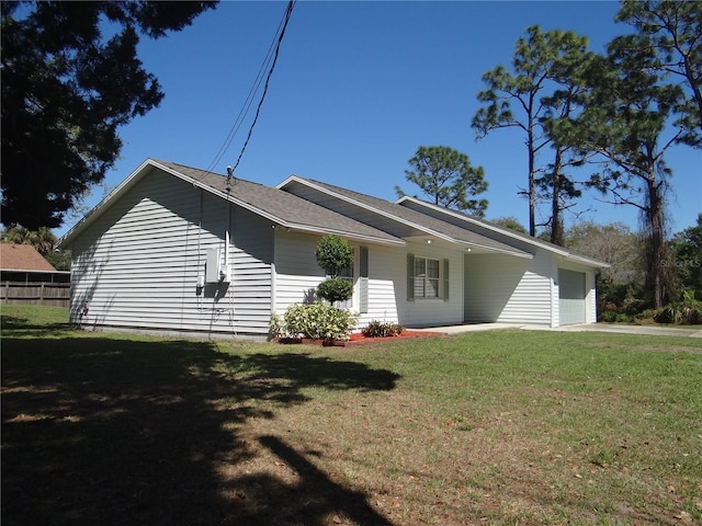 view of side of home featuring a garage, a yard, and driveway