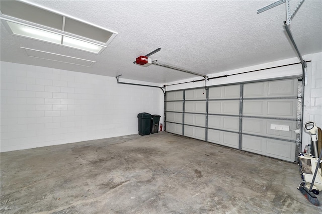 garage featuring a garage door opener and concrete block wall