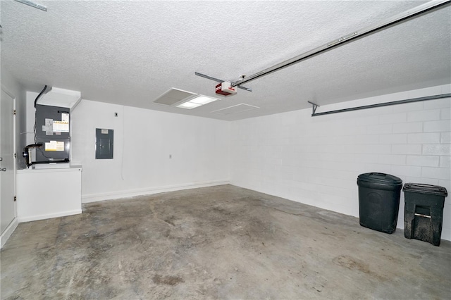 garage featuring electric panel, heating unit, a garage door opener, and concrete block wall