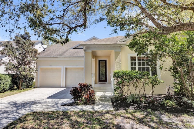 view of front of home featuring stucco siding, a garage, driveway, and a shingled roof