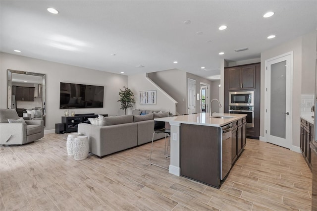 12654 Oak Hill Way, Parrish, FL 34219 - kitchen with a sink, stainless steel appliances, open floor plan, dark brown cabinetry, and light countertops