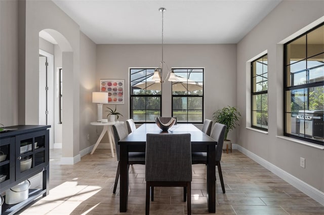12654 Oak Hill Way, Parrish, FL 34219 - dining room with healthy amount of natural light, arched walkways, baseboards, and a chandelier