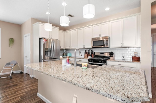 kitchen featuring visible vents, dark wood-style floors, white cabinetry, stainless steel appliances, and decorative backsplash