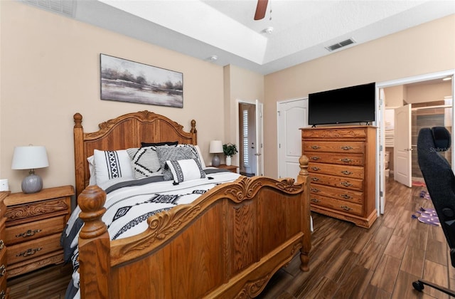 bedroom featuring ceiling fan, visible vents, and dark wood finished floors