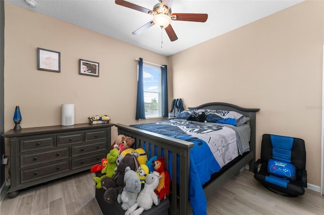 bedroom featuring baseboards, ceiling fan, and wood finished floors