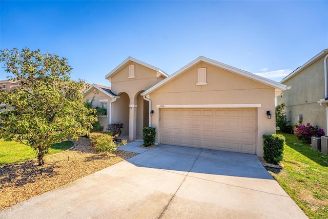 view of front of house with stucco siding, an attached garage, and concrete driveway