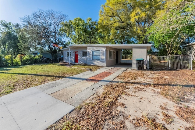 view of front facade featuring an attached carport, fence, driveway, and a front yard