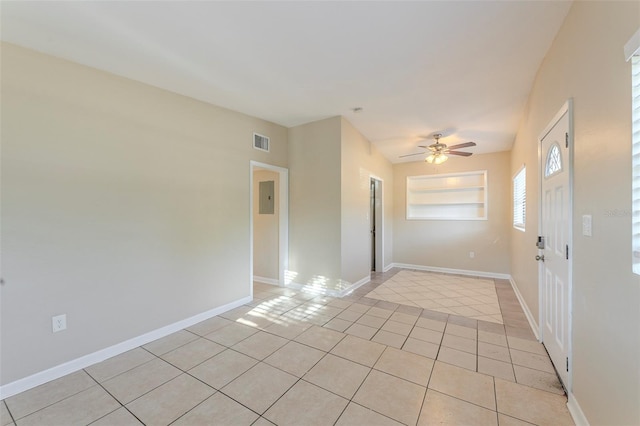 unfurnished room featuring light tile patterned floors, electric panel, a ceiling fan, visible vents, and baseboards