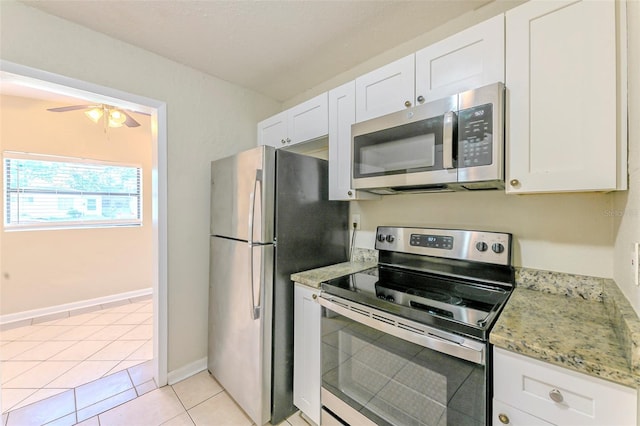 kitchen with light tile patterned flooring, a ceiling fan, appliances with stainless steel finishes, and white cabinetry