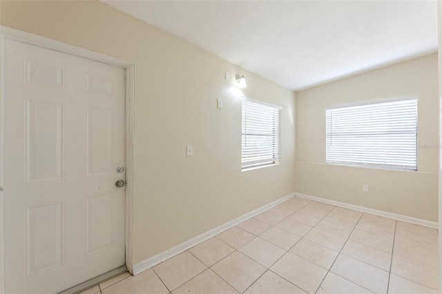 spare room with light tile patterned flooring and baseboards