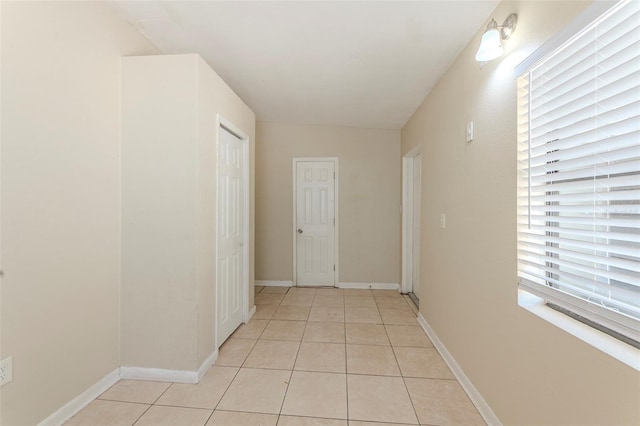 hall with light tile patterned floors and baseboards