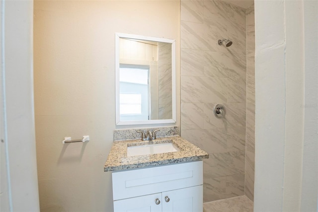 bathroom with vanity and tiled shower