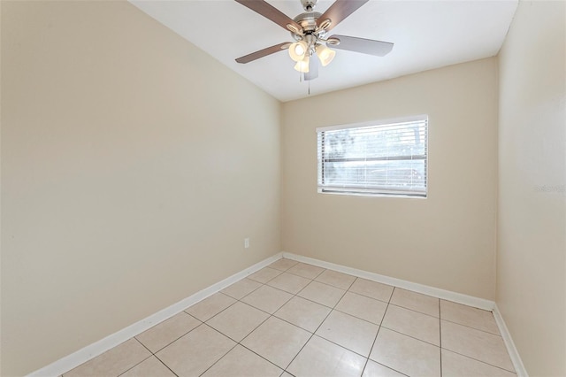 spare room featuring baseboards, light tile patterned floors, and ceiling fan