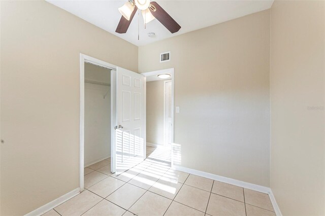 unfurnished bedroom featuring light tile patterned floors, visible vents, baseboards, and a closet