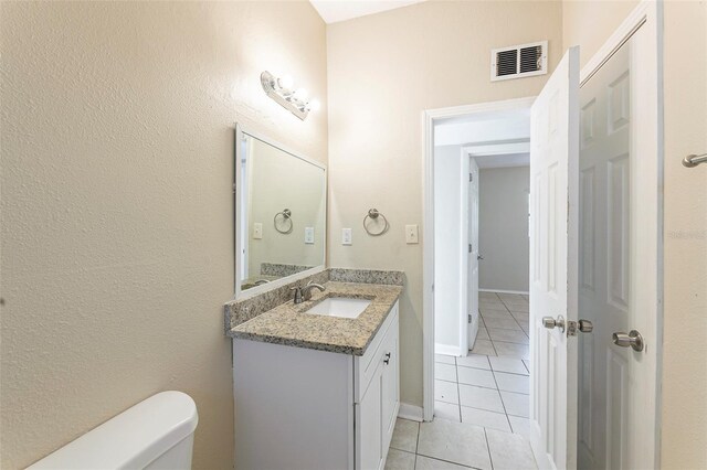 half bath featuring visible vents, toilet, tile patterned flooring, and vanity