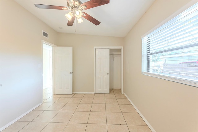 unfurnished bedroom with light tile patterned floors, visible vents, ceiling fan, baseboards, and a closet
