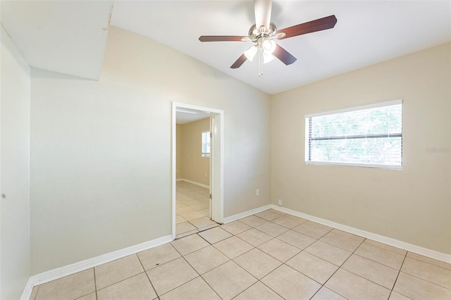 unfurnished room with light tile patterned floors, ceiling fan, lofted ceiling, and a healthy amount of sunlight