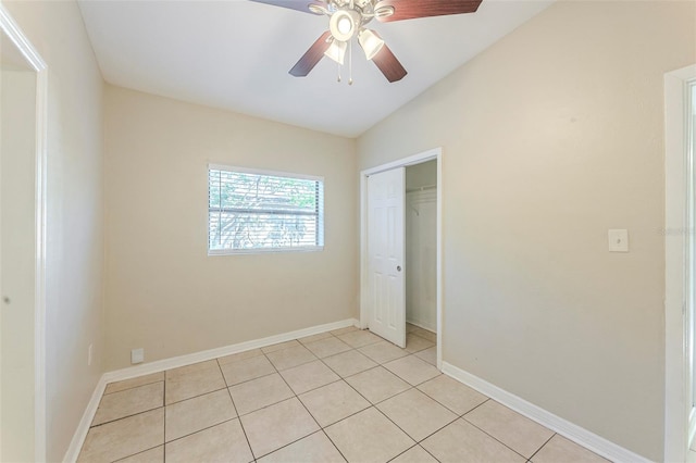 unfurnished bedroom with light tile patterned floors, a closet, ceiling fan, and baseboards