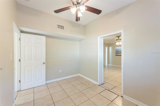 unfurnished room featuring baseboards, visible vents, light tile patterned floors, and ceiling fan